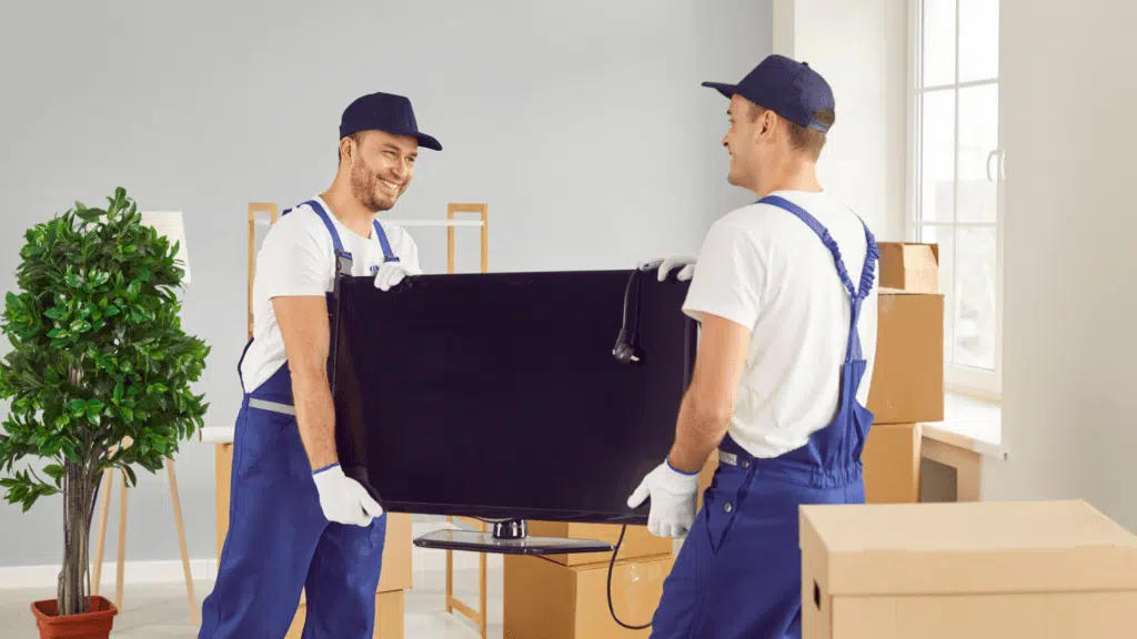 EZ-Haulin' team carefully removing an old television and loading it onto a truck for proper disposal or recycling.