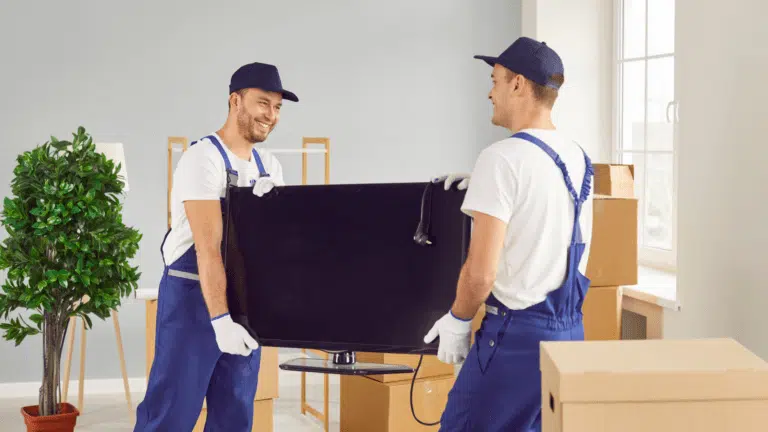 EZ-Haulin' team safely removing and loading an old TV onto a truck for recycling or proper disposal.