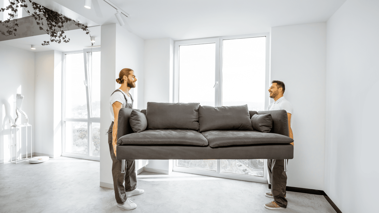 EZ-Haulin' team removing an old couch from a home and loading it onto a truck for disposal or recycling.