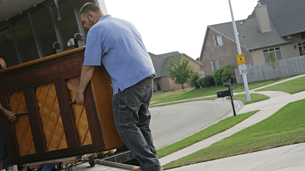 EZ-Haulin' team carefully moving and loading a piano onto a truck for safe disposal or relocation.