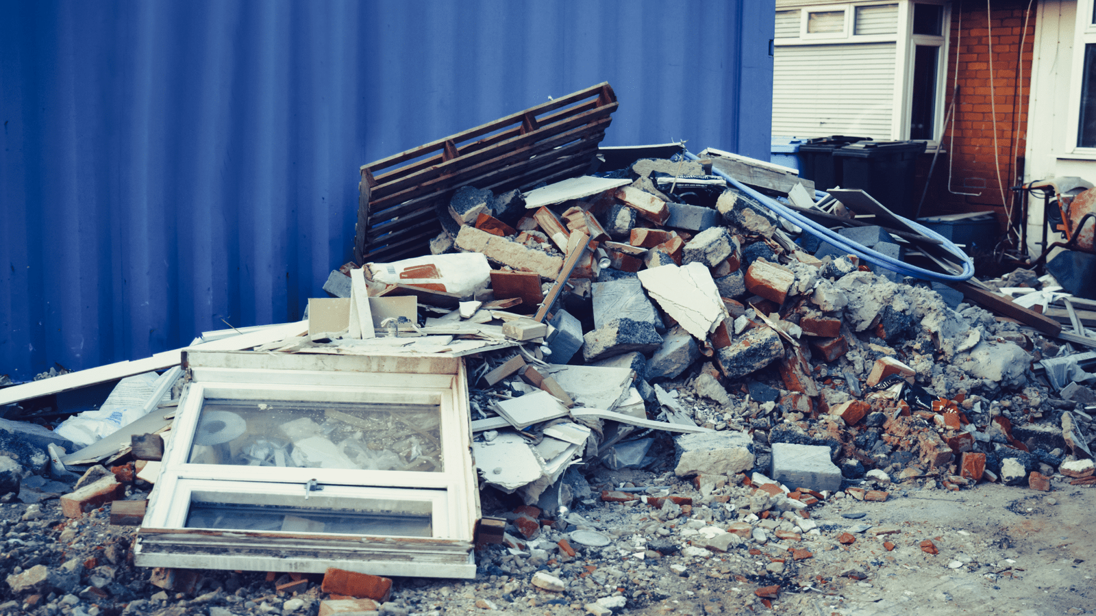 EZ-Haulin' team clearing and loading construction debris, including wood, drywall, and rubble, onto a truck for proper disposal.
