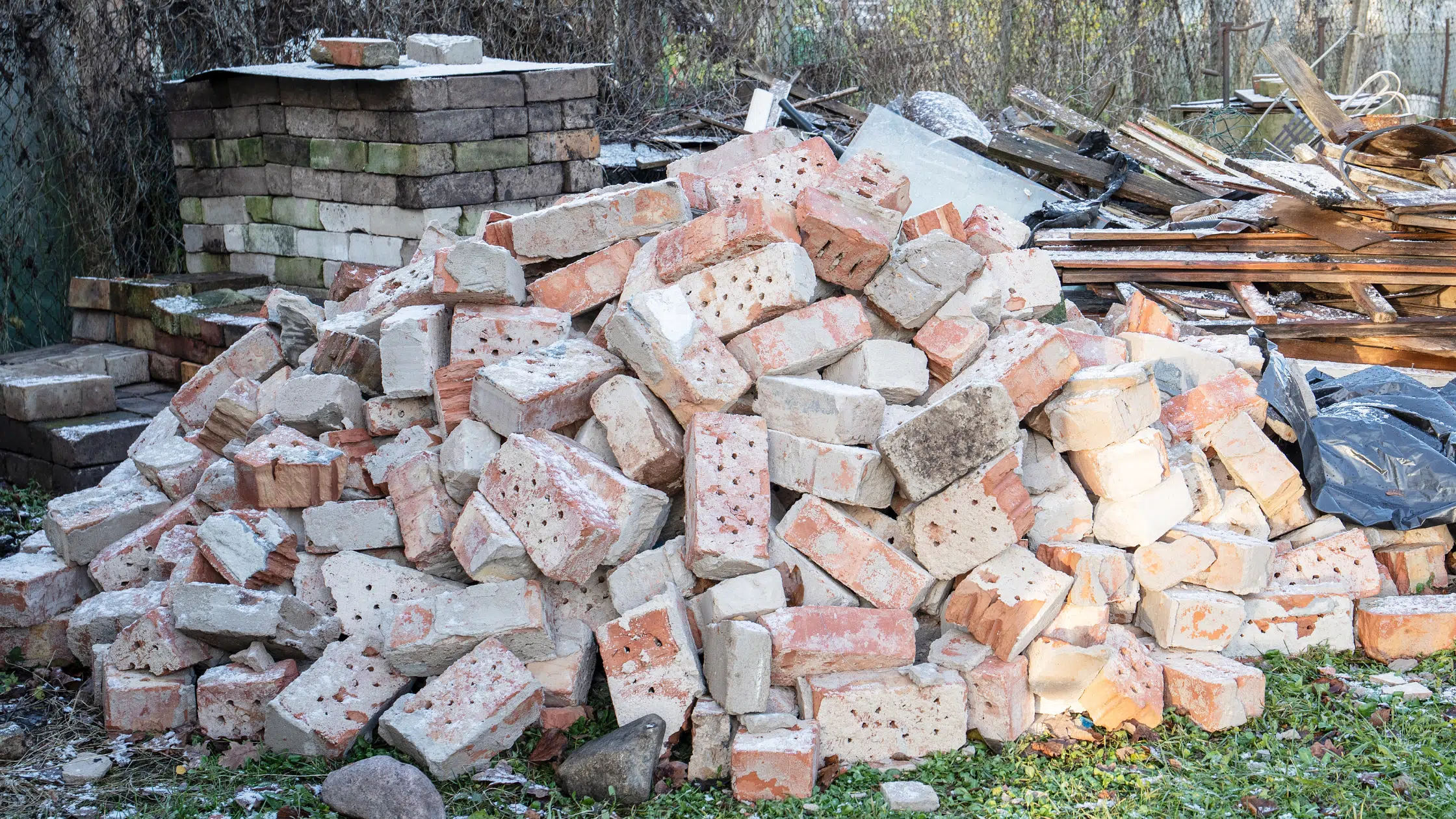 EZ-Haulin' team removing heavy brick and concrete debris from a construction site and loading it onto a truck for proper disposal.